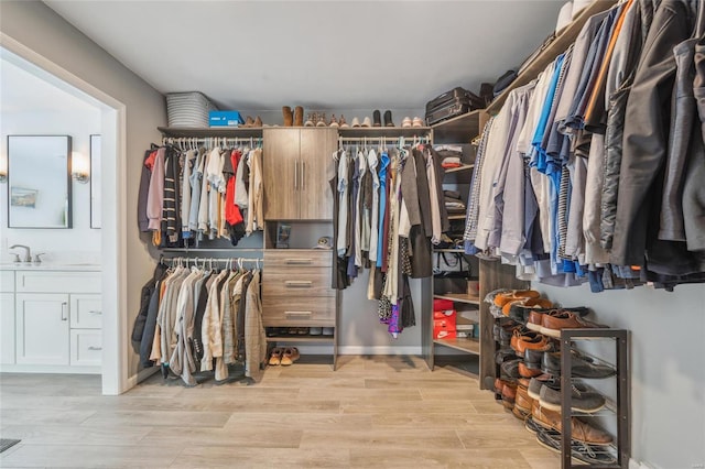 spacious closet with sink and light hardwood / wood-style flooring