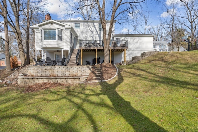 rear view of property featuring a wooden deck, a yard, ceiling fan, and a patio