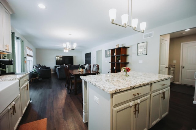 kitchen with a kitchen island, pendant lighting, a notable chandelier, and dark hardwood / wood-style flooring