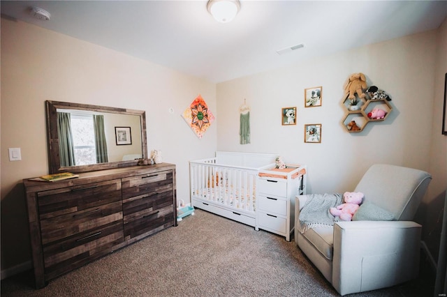 carpeted bedroom featuring a nursery area