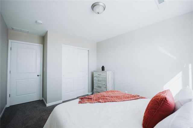 bedroom with a closet and dark colored carpet