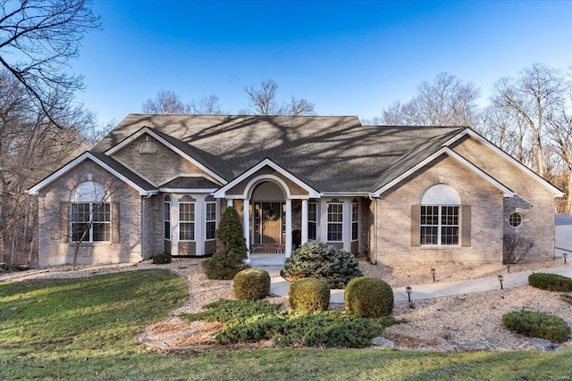 view of front facade featuring a front yard and brick siding