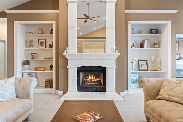 carpeted living area featuring built in features, a warm lit fireplace, vaulted ceiling, and ceiling fan