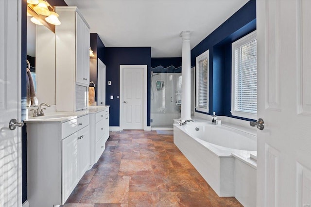 bathroom featuring a garden tub, decorative columns, a stall shower, a healthy amount of sunlight, and vanity