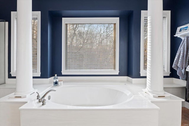 full bath with ornate columns and a garden tub