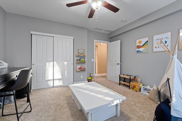 interior space with ceiling fan, a closet, and light colored carpet