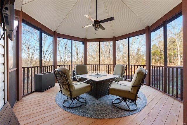 sunroom with a healthy amount of sunlight, a ceiling fan, and lofted ceiling