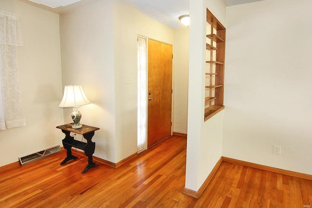 corridor with hardwood / wood-style flooring