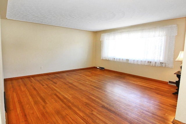 unfurnished room with wood-type flooring