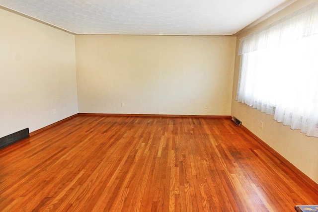 spare room with hardwood / wood-style floors