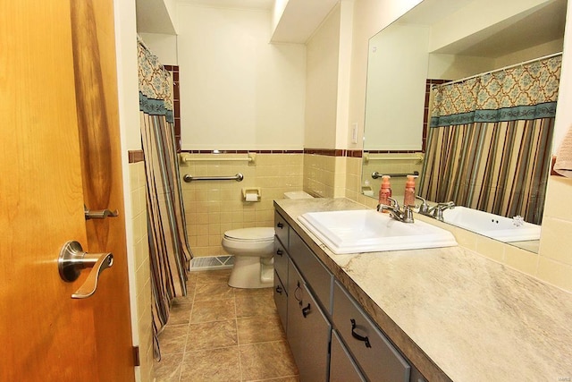 bathroom with vanity, tile patterned flooring, toilet, and tile walls