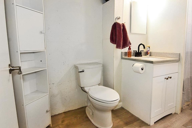 bathroom featuring vanity, wood-type flooring, and toilet