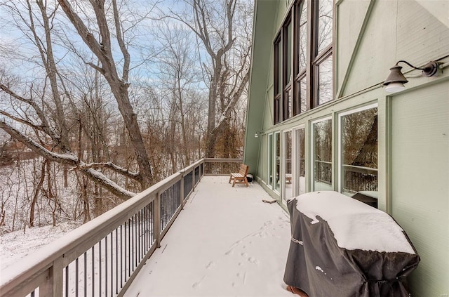 snow covered back of property featuring a grill