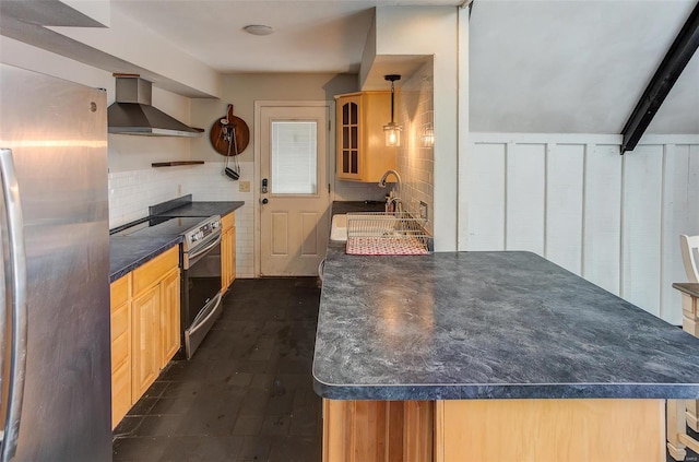 kitchen with tasteful backsplash, dark countertops, wall chimney exhaust hood, appliances with stainless steel finishes, and glass insert cabinets