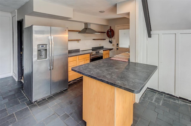 kitchen with stone tile floors, dark countertops, wall chimney exhaust hood, stainless steel appliances, and open shelves