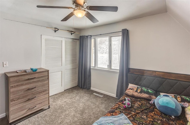 bedroom with lofted ceiling, visible vents, a ceiling fan, a closet, and dark colored carpet