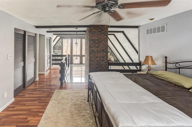 bedroom with baseboards, visible vents, dark wood-type flooring, and beamed ceiling