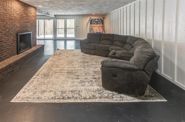 living area featuring concrete floors, a fireplace, and a textured ceiling