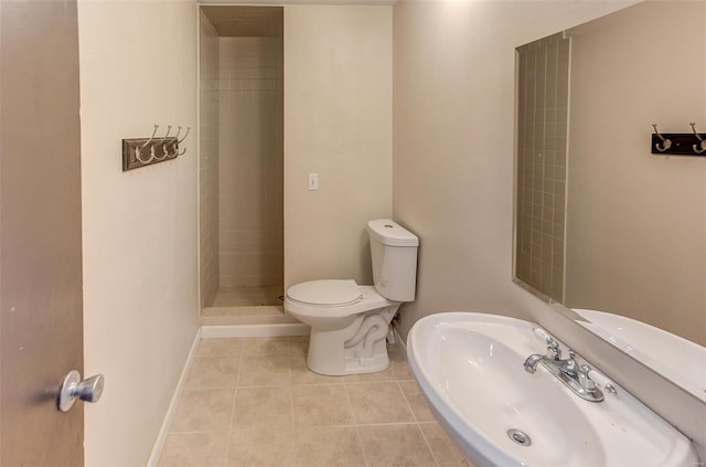 full bathroom with a stall shower, baseboards, toilet, tile patterned flooring, and a sink