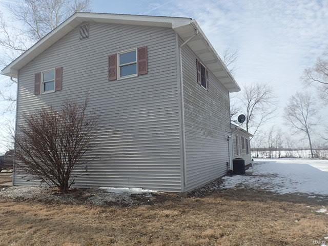 view of snow covered exterior with a yard