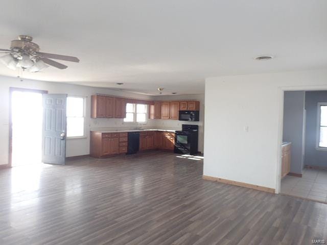 kitchen with dark wood-type flooring, black appliances, and ceiling fan