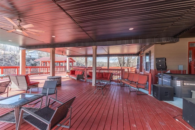 wooden deck with a gazebo, ceiling fan, outdoor lounge area, and a hot tub