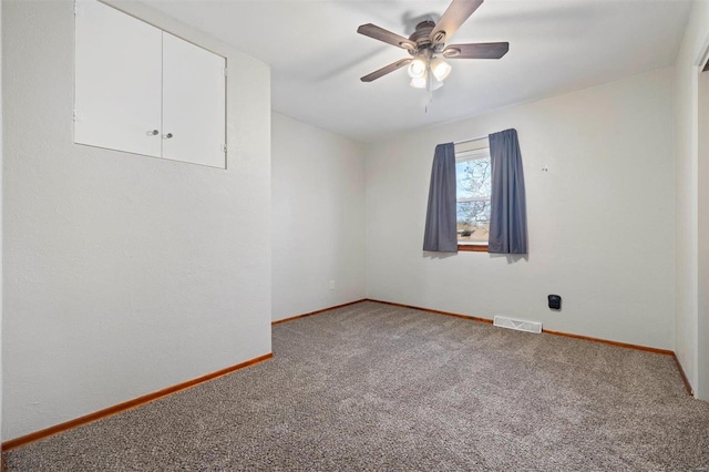 carpeted spare room featuring ceiling fan