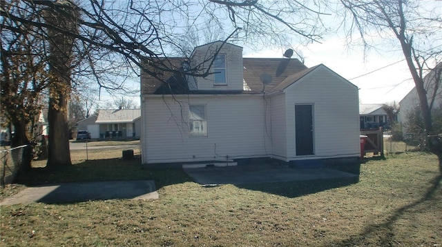 back of house featuring a patio area and a lawn