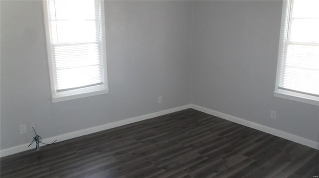 unfurnished room with plenty of natural light and dark wood-type flooring