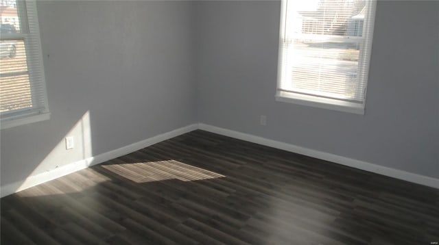 unfurnished room with dark hardwood / wood-style flooring