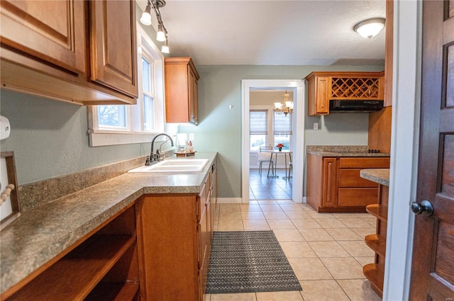 kitchen with an inviting chandelier, a wealth of natural light, sink, and light tile patterned floors