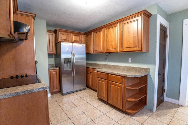 kitchen featuring black electric cooktop, light tile patterned floors, stainless steel fridge, and a textured ceiling