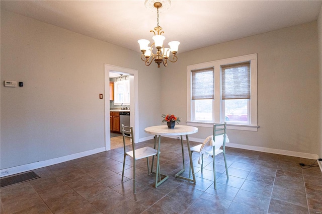 tiled dining space with sink and a notable chandelier