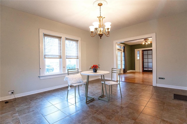 dining space with a notable chandelier and dark tile patterned flooring