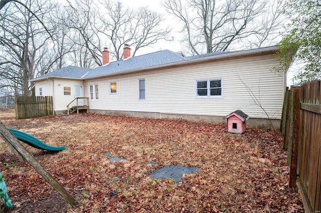 rear view of house featuring a playground