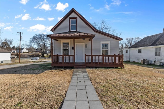 bungalow-style home featuring a front yard and covered porch