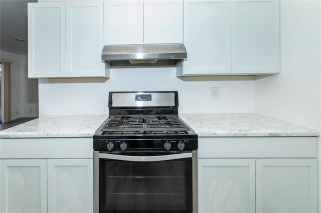 kitchen featuring stainless steel gas range oven, light stone counters, and under cabinet range hood