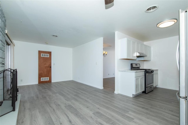 kitchen featuring light hardwood / wood-style floors, stainless steel range with gas stovetop, and white cabinets