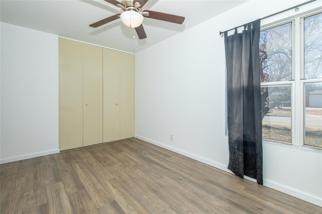 unfurnished bedroom with hardwood / wood-style flooring, ceiling fan, and a closet