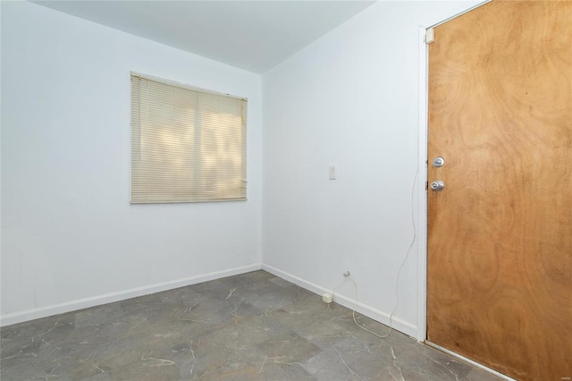 unfurnished room with baseboards