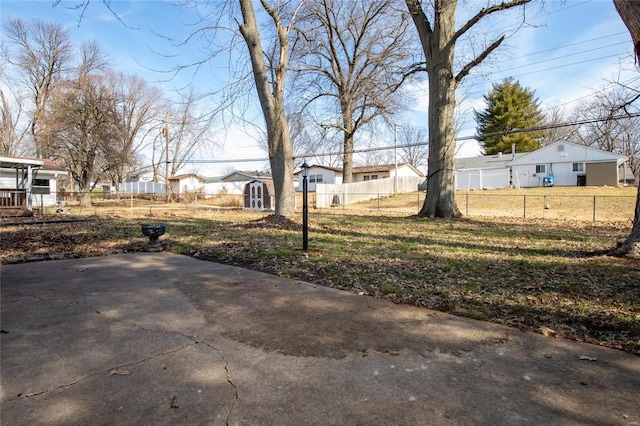 view of yard with a patio, an outdoor structure, fence private yard, and a residential view