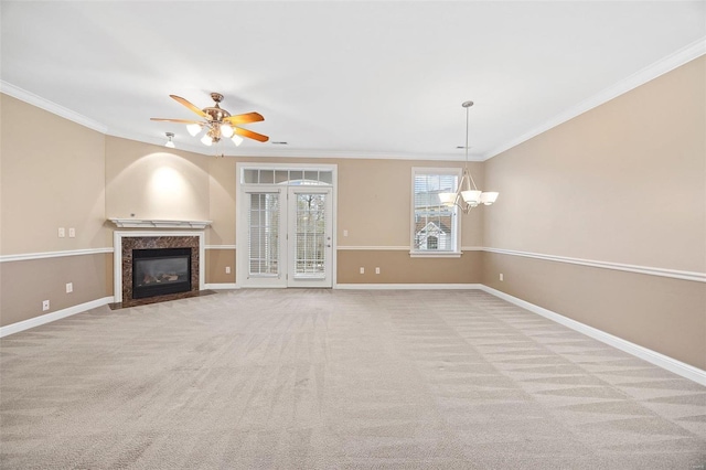 unfurnished living room with light carpet, ceiling fan with notable chandelier, a high end fireplace, and ornamental molding