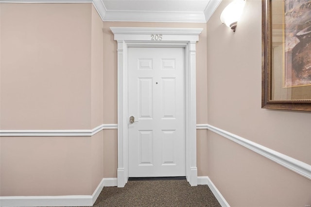 doorway to outside with ornamental molding and dark colored carpet