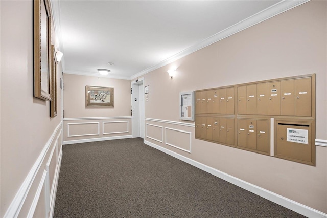 hallway with dark carpet, ornamental molding, and a mail area