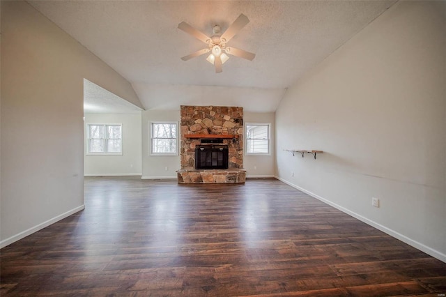 unfurnished living room with lofted ceiling, a textured ceiling, dark hardwood / wood-style floors, ceiling fan, and a fireplace