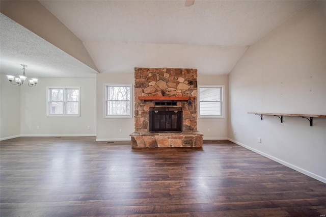 unfurnished living room featuring dark hardwood / wood-style flooring, a fireplace, vaulted ceiling, and a textured ceiling