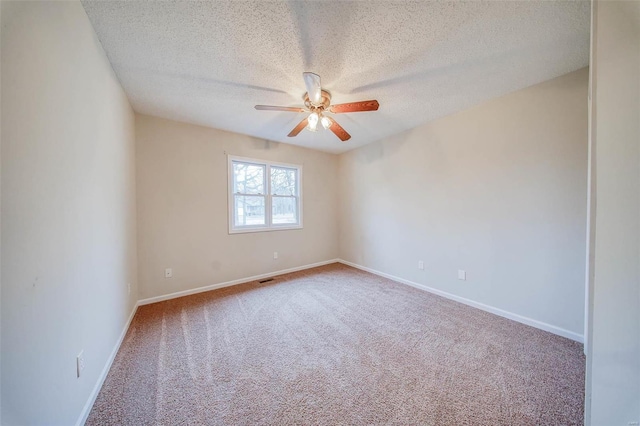 carpeted empty room featuring ceiling fan and a textured ceiling