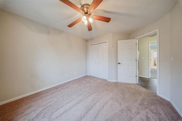 unfurnished bedroom featuring ceiling fan, a closet, a textured ceiling, and dark colored carpet