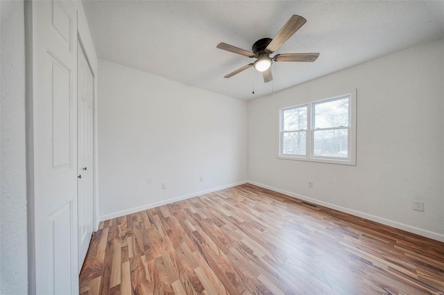 unfurnished bedroom with ceiling fan, a closet, and light hardwood / wood-style flooring