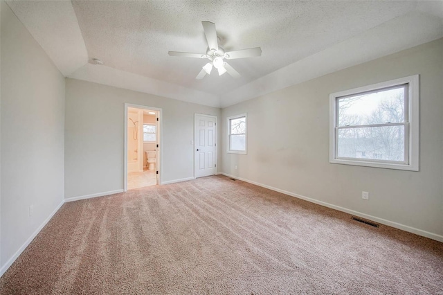 carpeted spare room featuring ceiling fan, a raised ceiling, and a textured ceiling